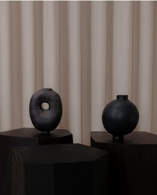 Dekoration mit Vasen vor Wellenvorhang