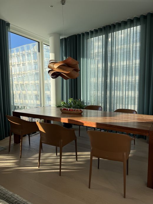 Penthouse-Essbereich mit petrolfarbenem Wellenvorhang
