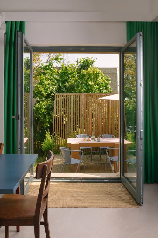 Modernes Wohnzimmer mit grünen Vorhängen und Terrassenblick