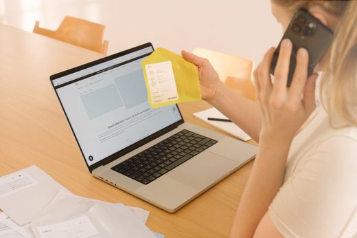 Frau telefoniert und hält gelbes Kvadrat Stoffmuster hoch